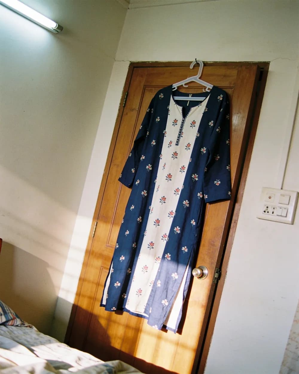 A phone photo of a kurti on a hanger